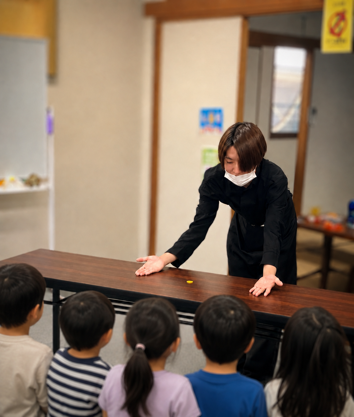 テーブルを囲んだお子さまたちに、マジックショーを披露する様子